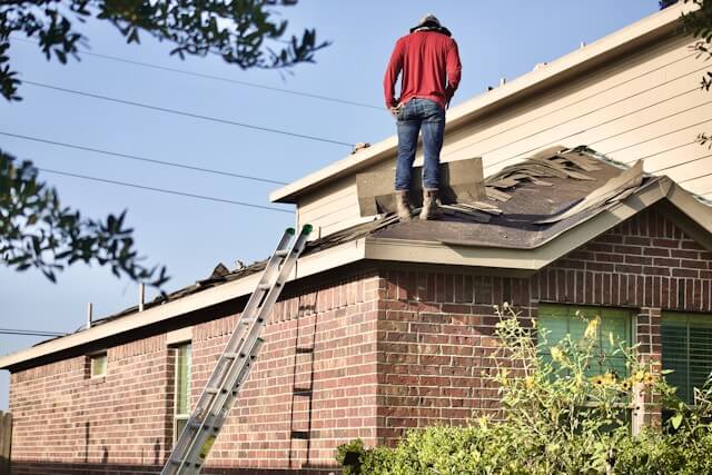 Roof inspector examining shingles and structure on a residential home